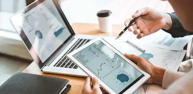 Advisor reviewing consolidated wealth reports on a tablet and laptop